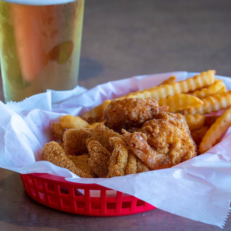 Fried shrimp and fish basket with crinkle fries and a cold beer